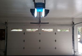 Chamberlain automatic garage door opener lifting a sectional garage door smoothly inside a residential Emerson garage.