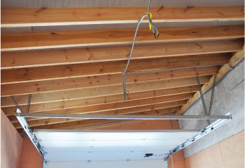 Interior view of a garage showing newly installed tracks and a partially open garage door, illustrating proper garage door assembly and maintenance in Cartersville, GA.