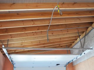 Interior view of a garage showing newly installed tracks and a partially open garage door, illustrating proper garage door assembly and maintenance in Cartersville, GA.