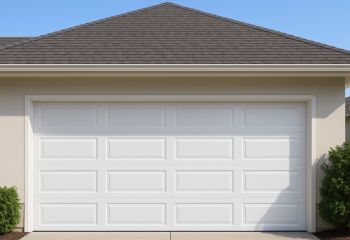 Front view of a newly installed white garage door with raised panels on a residential home in Adairsville, GA, showing a clean, finished look.