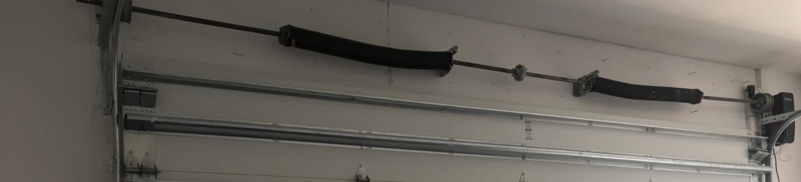 Close view of a residential garage interior in Cartersville, GA, showing a completed garage door spring installation and clean, organized workspace.